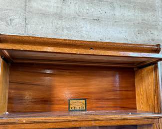 This lot features a stacking barrister bookcase manufactured by Globe Wernicke, dating back to the early 1900s. This bookcase in particular has a total of seven (7) pieces – 5 stacking bookcases, a base, and a topper. This piece measures from top to bottom, 79” H x 34” W x 11.5” D.


