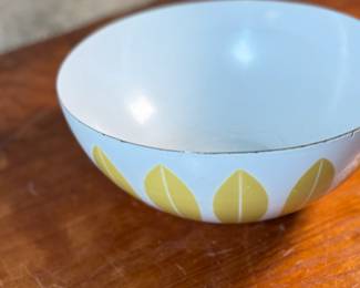 This lot features a vintage Cathrineholm Lotus enamelware bowl in white with a yellow (or mustard) leaf pattern. The design is a classic example of Mid-Century Modern Norwegian design. The bowl form and colors were created by designer Grete Prytz Kittelsen, while the iconic lotus pattern is attributed to Arne Clausen.

