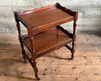 This lot features an antique English mahogany two-tier trolley or serving table, possibly Victorian era that measures, 30” H x 24” W x 16” D.

