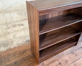 This lot features a three-shelf bookcase with a walnut veneer that measures, 36” H x 36” W x 12” D.

