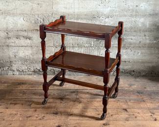 This lot features an antique English mahogany two-tier trolley or serving table, possibly Victorian era that measures, 30” H x 24” W x 16” D.

