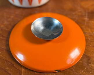 This lot features a vintage Cathrineholm Lotus enamel saucepan with a lid in an orange and white color scheme. The popular "Lotus" pattern was designed by Grete Prytz Kittelsen and produced during the early to mid-1960s in Norway.

