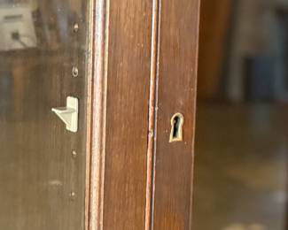 This lot features a large, solid wood cabinet with glass pane doors that measures, 84” H x 52” W x 13.5” D. This cabinet comes locked (no key) and without shelves.

