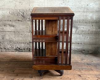 This lot features an antique Edwardian hardwood revolving bookcase, circa early 1900s, featuring vertical slatted sides and original castors. This bookcase measures, 33” H x 19” W x 19” D.


