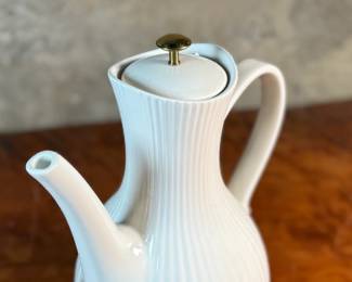 This lot features a vintage Ernest Sohn Creations "Doric" line white ribbed ceramic coffee server or teapot. It was designed by Ernest Sohn and produced by Hall China in the 1950s. This model typically holds around 10 to 12 cups of coffee or tea and measures, 12” H x 10” W x 6” D.

