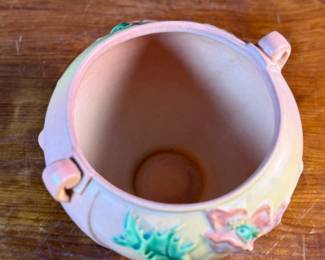 This lot features a Roseville Poppy jardiniere (or vase/planter) in very good condition. The Poppy line of art pottery was introduced by Roseville in 1938. It features raised poppy flowers and buds in a mauve or pink color with vivid green leaves against a shaded background. This vase measures, 6” H x 7.5” W x 7” D.

