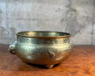 This lot features a large Mottahedeh brass bowl/planter with lion-design handles and clawed feet that measures, 5.75” H x 14” W x 11” D.

