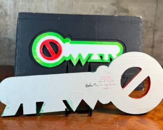 "Key, No War", an original mixed media sculpture by listed artist, Howard Hack. Included is also what appears to be the prototype for this series. Edition 5/50, hand-signed on the verso. Howard Edwin Hack (July 6, 1932 – June 11, 2015) was an American representational painter and graphic artist, with works in numerous museum collections. Known for an innovative approach to a variety of media, as well as use of traditional oil paints, Hack began working in the late 1940s.

