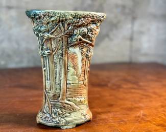 This lot features an antique Weller Pottery Forest vase. This design was created by Rudolph Lorber and produced between approximately 1915 and 1928. The vase measures, 8” H x 5.5” W x 3” D and comes in very good condition.

