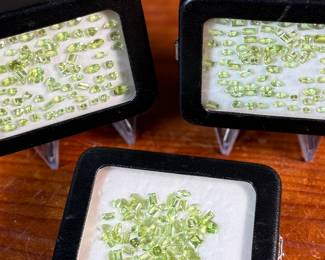 This lot features three (3) containers full of various sizes and cuts of peridot gemstones.

