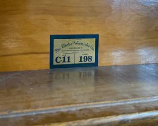 This lot features a stacking barrister bookcase manufactured by Globe Wernicke, dating back to the early 1900s. This bookcase in particular has a total of eight (8) pieces – 6 stacking bookcases, a base, and a topper. This piece measures from top to bottom, 90” H x 34” W x 11” D.

