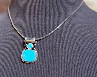 This lot features a beautiful sterling silver necklace with a silver & turquoise pendant. The chain measures, 18” and the necklace has a total approx. weight of 21.60 grams.

