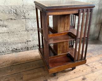 This lot features an antique Edwardian hardwood revolving bookcase, circa early 1900s, featuring vertical slatted sides and original castors. This bookcase measures, 33” H x 19” W x 19” D.


