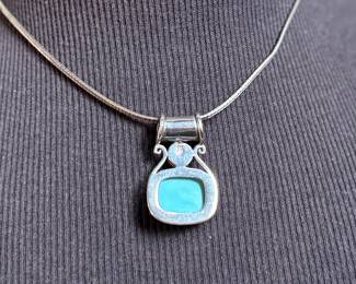 This lot features a beautiful sterling silver necklace with a silver & turquoise pendant. The chain measures, 18” and the necklace has a total approx. weight of 21.60 grams.

