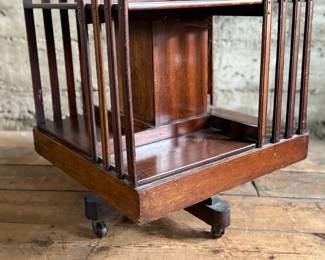 This lot features an antique Edwardian hardwood revolving bookcase, circa early 1900s, featuring vertical slatted sides and original castors. This bookcase measures, 33” H x 19” W x 19” D.


