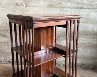This lot features an antique Edwardian hardwood revolving bookcase, circa early 1900s, featuring vertical slatted sides and original castors. This bookcase measures, 33” H x 19” W x 19” D.

