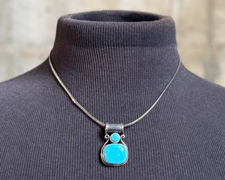 This lot features a beautiful sterling silver necklace with a silver & turquoise pendant. The chain measures, 18” and the necklace has a total approx. weight of 21.60 grams.

