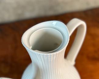 This lot features a vintage Ernest Sohn Creations "Doric" line white ribbed ceramic coffee server or teapot. It was designed by Ernest Sohn and produced by Hall China in the 1950s. This model typically holds around 10 to 12 cups of coffee or tea and measures, 12” H x 10” W x 6” D.

