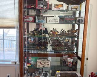 Howard Miller lighted  collector’s cabinet with glass display shelves and dual side entry doors