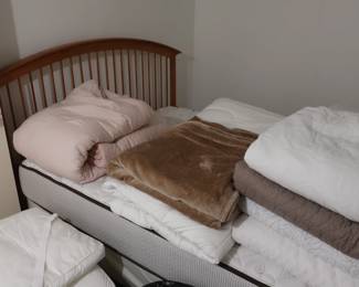 Double bed with frame. There is a lot of bedding.