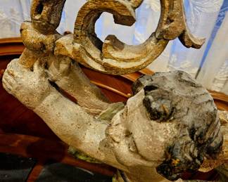 This is a pair of 18th-century Italian carved wooden cherubs.
They are hand-carved from wood and feature a parcel- painted finish with gold accents.
The cherubs present as reflections of each other with one holding a shield and the other a horn-like object.