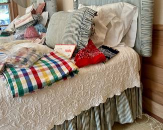 Upholstered twin beds with quantities of needlework