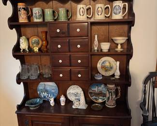 On this vintage display hutch, German steins and other drinking vessels, vases, plates, etc