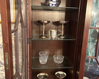top shelf:Crystal basket with blue made by an inlaw who worked for a crystal company. Around Neuss
Germany.  Produced in the 70s.  4” tall                                   2nd shelf: (4) EP Brass from Spain – silver plate over brass 8
champagne glasses – great for serving ice cream