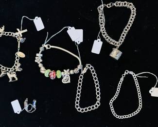 Close-up of sterling silver bracelets / USN pin