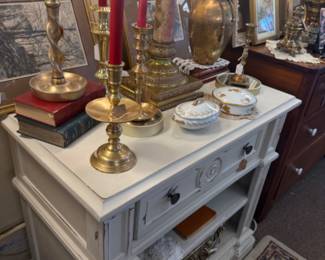 white end table, vintage brass candlesticks, trinket boxes, brass vase
