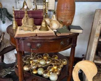 brass bells, wood end table, carved wooden swan, pottery, vinage brass candlesticks, books