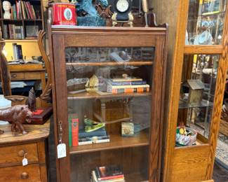 beautiful antique oval book shelf with single door, horse head figurine, clock, book end, pheasant figurine