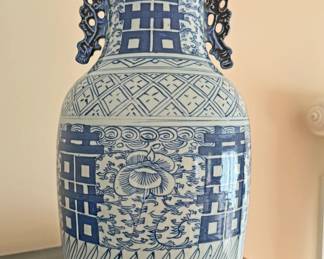 Chinese blue and white porcelain baluster vase with applied handles, often referred to as a "Double Happiness" vase due to the repeating stylized character for "shuangxi" (double happiness or marriage bliss) within the square panels. The vase features various traditional motifs, including geometric patterns, floral scrolls, and vertical lines around the base, and is in the style of the Qing Dynasty (1644–1912). 