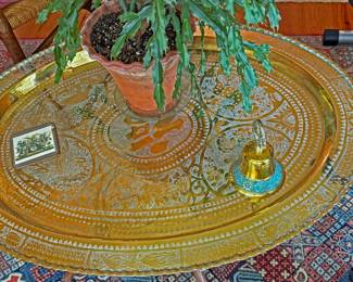 Vintage, large oval brass tray table with a folding wooden base, often referred to as a Moroccan, Middle Eastern, or Anglo-Indian style 