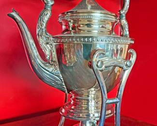 Antique silver tilting kettle on a stand  