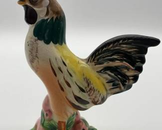 A vintage, handpainted ceramic rooster figurine on a decorative base.