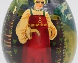 Russian wooden lacquer egg handpainted with traditional folk art motifs.