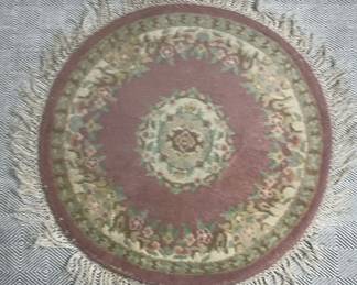 IndoAubusson style rug with floral motifs and fringe. 36 In round