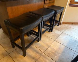
Three counter height, wood and leather barstools