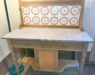 Antique marble-top wash basin with tiled backsplash