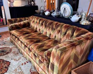 Retro colorful couch with two cylindrical pillows with geometric designs