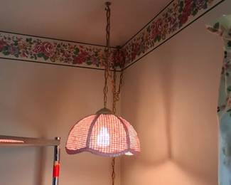 vintage swag lamp features a hanging chain and a woven rattan-style shade