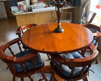 Round wooden kitchen table with four captains chairs, sturdy!