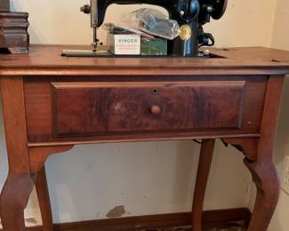 Vintage Singer sewing machine in cabinet with accessories
