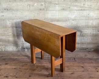 This lot features a stunning solid oak drop-leaf table, possibly manufactured by Gustav Stickley (no maker sticker present). This table measures (open), 30” H x 40” W x 42” D and (closed), 30” H x 14” W x 42” D.

