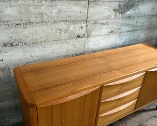 This lot features the Orvar sideboard by Scandinavian Designs. Crafted in teak, this cabinet measures, 29.5” H x 66” W x 20” D. Three large drawers and two cabinets provide ample space for hosting and dining accoutrement.

