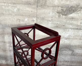 This lot features a library book stand, made of teak with a mahogany finish. This stand measures, 40.5” H x 20” W x 14” D.  The simple neoclassical fretwork on the sides and back gives it great visual distinction. Wide glass shelves provide ample storage, with a special tilting shelf on top for an atlas, dictionary or other frequently consulted volumes. All glass inserts included (not photographed).

