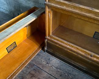 This lot features a stacking barrister bookcase manufactured by Globe Wernicke, dating back to the early 1900s. This bookcase in particular has a total of five (5) pieces – 3 stacking bookcases, a base, and a topper. This piece measures from top to bottom, 49.5” H x 34” W x 11” D. This lot also includes two (2) additional stacking bookcases that are missing the glass to be used as is or repaired.

