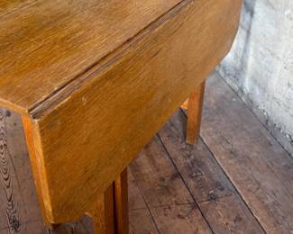 This lot features a stunning solid oak drop-leaf table, possibly manufactured by Gustav Stickley (no maker sticker present). This table measures (open), 30” H x 40” W x 42” D and (closed), 30” H x 14” W x 42” D.

