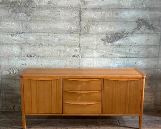 This lot features the Orvar sideboard by Scandinavian Designs. Crafted in teak, this cabinet measures, 29.5” H x 66” W x 20” D. Three large drawers and two cabinets provide ample space for hosting and dining accoutrement.

